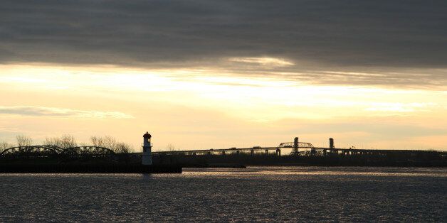 'Back lit lighthouse, and Mercier Bridge with morning traffic, a December morning.Lake Saint-Louis, or in French Lac Saint-Louis, is a lake in extreme southwestern Quebec, Canada, adjoining the Island of Montreal at the confluence of the Saint Lawrence and Ottawa Rivers. One can actually see a line in the middle of the lake where the two different-coloured waters meet.'