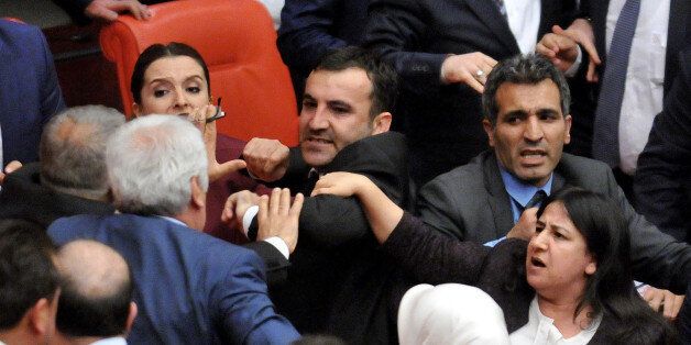 Turkish lawmakers pushe each other after a brawl erupted on the assembly floor, after a pro-Kurdish lawmaker accused the security forces of