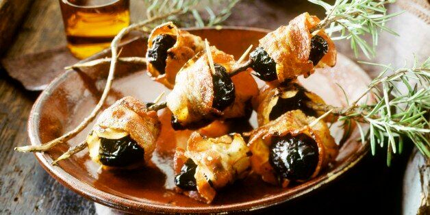 Bacon-wrapped prunes with rosemary & glass of sherry on tray