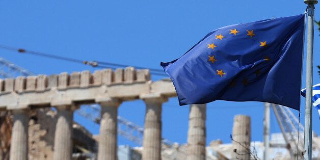 ATHENS, GREECE - JULY 12: An EU flag flys in front of the ancient Parthenon temple on top of the Acropolis hil on July 12, 2015 in Athens, Greece. The people of Greece continue their daily life as much as possible as a planned meeting of European Union leaders is cancelled during 'very difficult' talks over Greece's third bailout continue. Eurozone finance ministers adjourned the talks last night and are set to resume today. (Photo by Christopher Furlong/Getty Images)