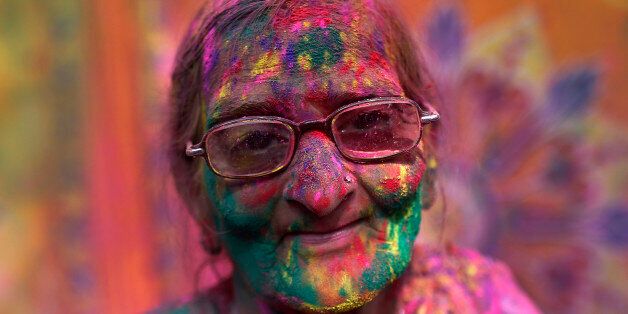 A widow daubed in colours takes part in Holi celebrations organised by non-governmental organisation Sulabh International at a widows' ashram at Vrindavan, in the northern Indian state of Uttar Pradesh March 3, 2015. Traditionally in Hindu culture, widows are expected to renounce earthly pleasure so they do not celebrate Holi. But women at the shelter for widows, who have been abandoned by their families, celebrated the festival by throwing flowers and coloured powder. Holi, also known as the Festival of Colours, heralds the beginning of spring and is celebrated all over India. REUTERS/Ahmad Masood (INDIA - Tags: RELIGION SOCIETY ANNIVERSARY)