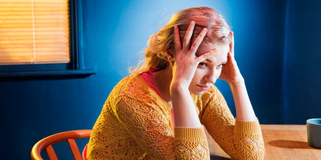 Woman thinking, sitting at table.