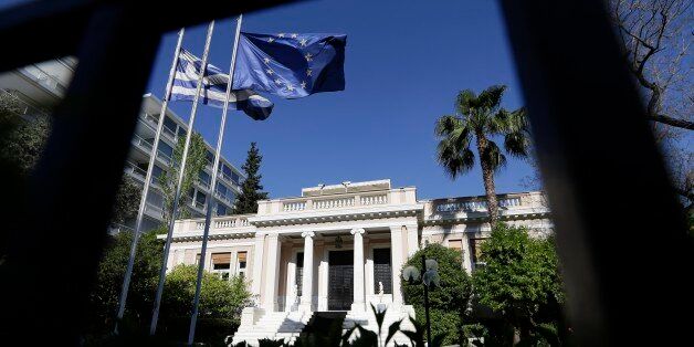 The Greek and the European Union flags are wave outside Maximos Mansion, office of the Prime Minister during a ministerial meeting in Athens, Wednesday, May 13, 2015. Greece's prime minister Alexis Tsipras was holding his second ministerial meeting in as many days Wednesday, when official data confirmed the cash-strapped country is back in recession amid concern over much-delayed bailout talks with creditors. (AP Photo/Thanassis Stavrakis)
