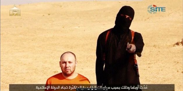 A masked, black-clad militant, who has been identified by the Washington Post newspaper as a Briton named Mohammed Emwazi, stands next to a man purported to be Steven Sotloff in this still image from a video obtained from SITE Intel Group website February 26, 2015. The