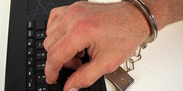 Hand in handcuffs and keys against a white background