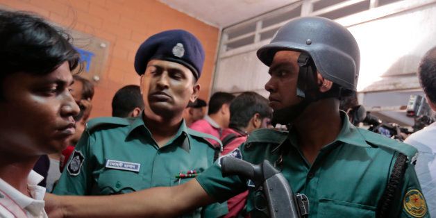 Bangladeshi policemen try to control the crowd of onlookers at a building where two people were found stabbed to death in Dhaka, Bangladesh, Monday, April 25, 2016. Police in Bangladesh say unidentified assailants have stabbed two men to death, including a gay rights activist who also worked for the U.S. Agency for International Development.(AP Photo/A.M.Ahad)