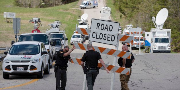 Authorities set up road blocks at the intersection of Union Hill Road and Route 32 at the perimeter of a crime scene, Friday, April 22, 2016, in Pike County, Ohio. Shootings with multiple fatalities were reported along a road in rural Ohio on Friday morning, but details on the number of deaths and the whereabouts of the suspect or suspects weren't immediately clear. The attorney general's office said a dozen Bureau of Criminal Investigation agents had been called to Pike County, an economically struggling area in the Appalachian region some 80 miles east of Cincinnati. (AP Photo/John Minchillo)