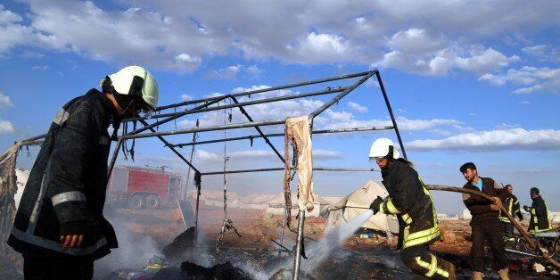 IDLIB, SYRIA - MAY 05: Firefighters extinguish fire after a Syrian regime warcraft targeted the Kamuna refugee camp near the Sarmada town of Idlib province, Syria on May 05, 2016. Eight people were killed and another 30 injured when a regime warcraft targeted the Kamuna refugee camp. (Photo by Abdulfetah Huseyin/Anadolu Agency/Getty Images)