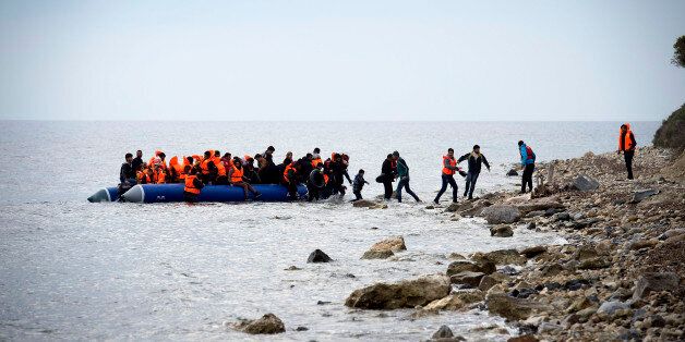 MYTELENE, GREECE - MARCH 09: Syrian refugees arrive on an inflatable boat with other refugee after crossing the sea from Turkey to Lesbos, some 5 kilometres south of the capital of the Island, Mytelene on March 9, 2016 in Mytelene, Greece. Six inflatable boats reached during the night the beaches of Lesbos, as well as another 3 during the morning hours. The Greek Coast Guard picked up another dinghie and brought the refugees to the port of Mytelene. Joined Forces of the Standing NATO (North Atlantic Treaty Organisation) Maritime Group 2, including German Navy supply vessel 'Bonn' have arrived at the coast of the greek Island of Lesbos today in order to patrol between the coast of Turkey and Greece. Turkey has announced today to take back illegal migrants from Syria and to exchange those with legal migrants. (Photo by Alexander Koerner/Getty Images)