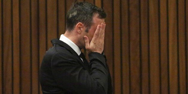 Oscar Pistorius covers his face in the dock at the High Court in Pretoria, South Africa, Tuesday Dec. 8, 2015. Pistorius wants to take his case to the Constitutional Court, challenging an appeals court that convicted him of murdering girlfriend Reeva Steenkamp, the Olympian's lawyer said. (AP Photo/Siphiwe Sibeko, Pool)