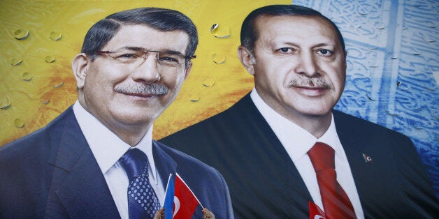 Supporters of the ruling AK Party hold national and party flags as they stand in front of a banner showing Turkish President Tayyip Erdogan and Prime Minister Ahmet Davutoglu (L) together during an election rally in the central Anatolian city of Konya, Turkey, October 30, 2015. REUTERS/Umit Bektas/File Photo