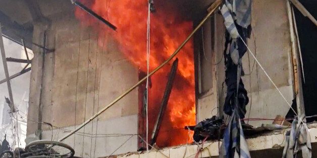 This image made from video and posted online from Validated UGC, shows a building on fire after airstrikes hit Aleppo, Syria, Thursday, April 28, 2016. A Syrian monitoring group and a first-responders team say new airstrikes on the rebel-held part of the contested city of Aleppo have killed over a dozen people and brought down at least one residential building. The new violence on Thursday brings the death toll in the past 24-hours in the deeply divided city to at least 61 killed. (Validated UGC via AP video)