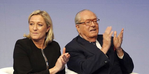 FILE - In this Saturday Nov. 29, 2014 file photo, French far-right Front National leader Marine Le Pen and her father Jean-Marie Le Pen applaud in Lyon, central France. A French court has reinstated Thursday July 2, 2015 Jean-Marie Le Pen as a member of the far right National Front party he founded decades ago, sending a biting blow to his daughter and party president Marine Le Pen, who had suspended him after a series of controversial and anti-Semitic statements. (AP Photo/Laurent Cipriani, File)