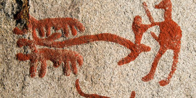 Bronze age rock art showing a man with two bulls ploughing with a wooden plough at the Rock Carvings In Tanum World Heritage site in Sweden