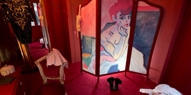 A copy of a painting by Andre Derain titled Woman in a Chemise of a Dancer (1906) is painted on a folding screen in a brothel setting in the Red Light District, part of an installation of three mock prostitute's rooms set up to promote the Easy Virtue exhibition at the Van Gogh Museum in Amsterdam, Netherlands, Tuesday, March 15, 2016. The Van Gogh Museum is dedicating a new exhibition to the world's oldest profession, examining the fascination for prostitution among artists like Van Gogh, Edgar Degas and Henri de Toulouse-Lautrec. The exhibit can be viewed from from Feb. 19 till June 19, 2016. (AP Photo/Peter Dejong)