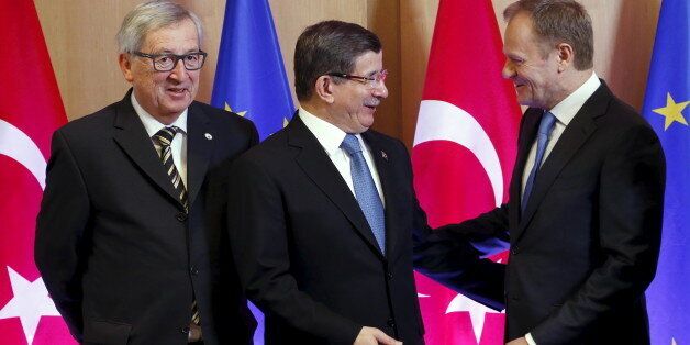 Turkish Prime Minister Ahmet Davutoglu poses with European Commission President Jean-Claude Juncker (L) and European Council President Donald Tusk (R) during an EU-Turkey summit in Brussels, as the bloc is looking to Ankara to help it curb the influx of refugees and migrants flowing into Europe, March 7, 2016. REUTERS/Francois Lenoir