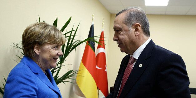 Turkey's President Recep Tayyip Erdogan, right, and German Chancellor Angela Merkel shake hands during the COP21, United Nations Climate Change Conference, in Le Bourget, outside Paris, France, Monday, Nov. 30, 2015. (Yasin Bulbul, Presidential Press Service, Pool via AP)