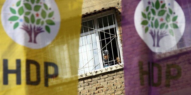 A woman and a boy look out of a balcony as election banners of the pro-Kurdish Peoples' Democratic Party (HDP) hang outside in Diyarbakir, Turkey October 31, 2015. President Tayyip Erdogan is unambiguous about what he wants from an election on Sunday, casting it as a pivotal moment for Turkey: a return to the single-party rule he presided over for more than a decade until June. REUTERS/Sertac Kayar