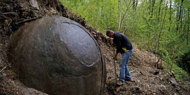 Suad Keserovic cleans a stone ball in Podubravlje village near Zavidovici, Bosnia and Herzegovina April 11, 2016. Keserovic claimed that the stone sphere is 3.30 meter in diameter and the estimated weight of it is about 35 tons. Hundreds of tourists from around the world have visited this stone. REUTERS/Dado Ruvic