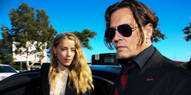 US actor Johnny Depp (R) and his wife Amber Heard arrive at a court in the Gold Coast on April 18, 2016. Depp and Heard arrived at an Australian court April 18 over Heard's alleged illegal importation of their two Yorkshire terrier dogs Boo and Pistol into the country in a private jet in 2015, as Depp was in Australia for the filming of the latest Pirates of the Carribean movie. / AFP / Patrick HAMILTON (Photo credit should read PATRICK HAMILTON/AFP/Getty Images)