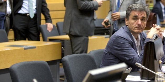 Greek Finance Minister Euclid Tsakalotos, right, waits for the start of a round table meeting of eurogroup finance ministers at the EU Lex building in Brussels on Sunday, July 12, 2015. Greece has another chance Sunday to convince skeptical European creditors that it can be trusted to enact wide-ranging economic reforms which would safeguard its future in the common euro currency. (AP Photo/Virginia Mayo)