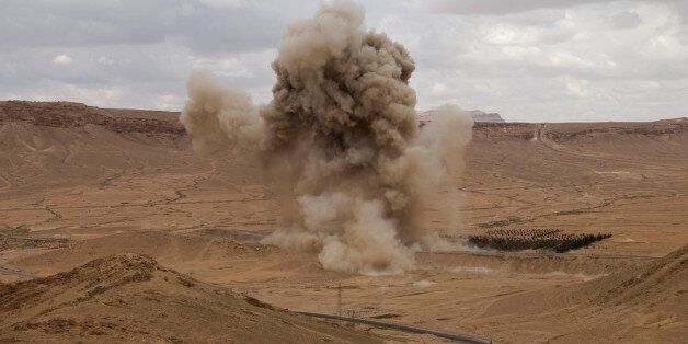 FILE - In this Thursday, April 14, 2016 photo, smoke rises from a controlled land mine detonation by Russian experts in the ancient town of Palmyra in the central Homs province, Syria. Russian combat engineers arrived in Syria on a mission to clear mines in Palmyra, which has been recaptured from Islamic State militants in an offensive that has proven Russia's military might in Syria despite a drawdown of its warplanes. (AP Photo/Hassan Ammar, File)