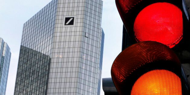 Traffic lights stand near the headquarters of Deutsche Bank in Frankfurt, Germany, Wednesday, Jan. 27, 2016. The bank's CEO John Cryan will talk about the earns in 2015 during a press conference on Thursday. (AP Photo/Michael Probst)
