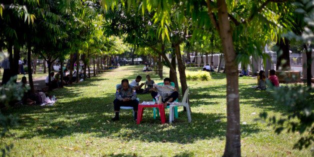 Police officers sit in the shade of a tree in a hot humid day at a public park in Yangon, Myanmar, Thursday, March 17, 2016. In Yangon during the month of March, temperature rises up to 37 degrees Celsius (98 degrees Fahrenheit) with up to 94 percent humidity before the tropical rainy season starts in May. (AP Photo/Gemunu Amarasinghe)
