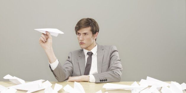 businessman, man, grey suit, white shirt, grey tie, wooden table, paper aeroplanes, aeroplane, folded paper