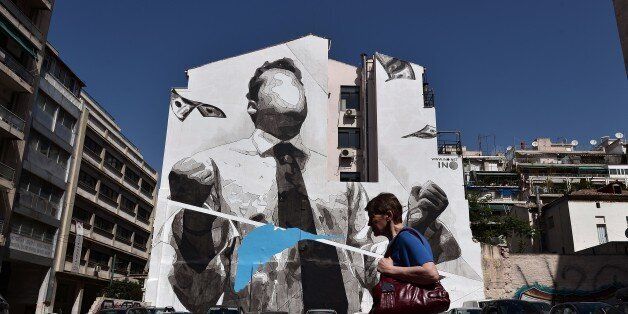 A woman walks past a mural by Greek street artist INO in Athens on April 20, 2016.Talks with EU-IMF creditors continue in Athens on a delayed reforms audit that Greece hopes to conclude by May 1.== RESTRICTED TO EDITORIAL USE - MANDATORY MENTION OF THE ARTIST UPON PUBLICATION - TO ILLUSTRATE THE EVENT AS SPECIFIED IN THE CAPTION == / AFP / LOUISA GOULIAMAKI / RESTRICTED TO EDITORIAL USE - MANDATORY MENTION OF THE ARTIST UPON PUBLICATION - TO ILLUSTRATE THE EVENT AS SPECIFIED IN THE CAPTION (Photo credit should read LOUISA GOULIAMAKI/AFP/Getty Images)