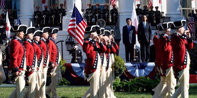President Barack Obama and Japanese Prime Minister Shinzo Abe watch as the United States Army Old Guard Fife and Drum Corps march past on the South Lawn of the White House in Washington, Tuesday, April 28, 2015, during a state arrival ceremony for the prime minister. (AP Photo/Susan Walsh)