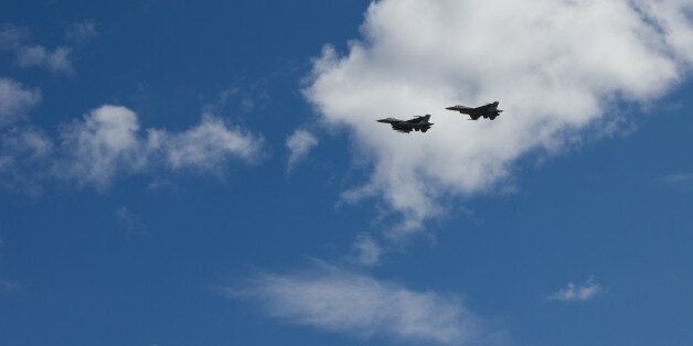 Two F-16s flying past at an airshow in Kristiansand, Norway. Beautifully contrasted in front of white clouds.