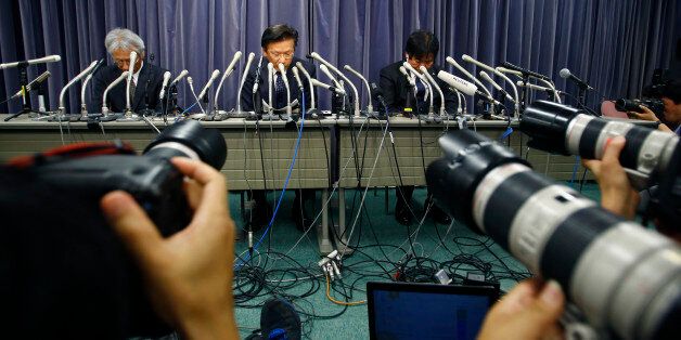 Mitsubishi Motors President Tetsuro Aikawa, center, listens to a reporter's question during a press conference in Tokyo, Wednesday, April 20, 2016. Mitsubishi Motors Corp. said Wednesday it used improper testing methods to make some of its vehicle models look more fuel efficient than they actually are. (AP Photo/Shizuo Kambayashi)