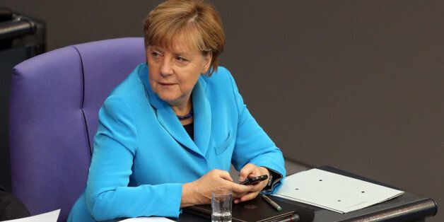 BERLIN, GERMANY - SEPTEMBER 09: German Chancellor Angela Merkel (CDU) uses her mobile phone as she attends a session of the Bundestag, the German parliament, on September 9, 2015 in Berlin, Germany. Merkel spoke primarily about the refugee crisis currently being faced by Europe, and has stressed that a European Commission (EC) plan to spread 160,000 migrants among European Union member countries may not be sufficient as the Continent may need to be prepared to receive an even higher number of asylum seekers in the current wave. (Photo by Adam Berry/Getty Images)