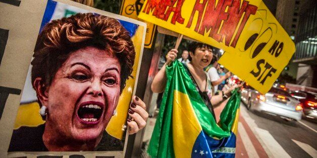 SAO PAULO, BRAZIL - APRIL 14: A woman holds a banner during a protest against the government of president of Brazil Dima Roussef at Paulista Avenue on April 14, 2016 in Sao Paulo, Brazil. Goverment of Brazil is attempting to block efforts to impeach President Dilma Roussefff by asking the Supreme Court to annul the process in Congress and suspend a key vote scheduled for Sunday. (Photo by Chris Faga/LatinContent/Getty Images)
