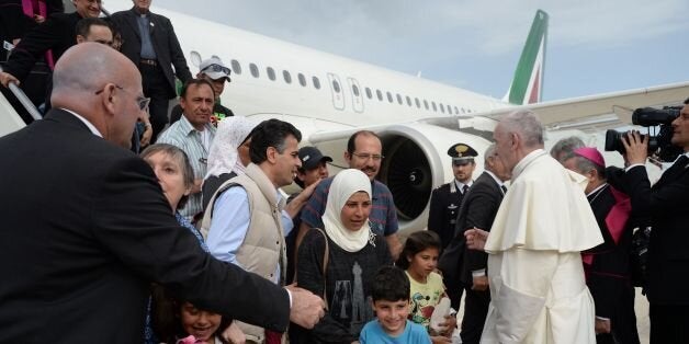 Pope Francis welcomes a group of Syrian refugees after landing at Ciampino airport in Rome following a visit at the Moria refugee camp on April 16, 2016 in the Greek island of Lesbos. Twelve Syrian refugees were accompanying Pope Francis on his return flight to Rome after his visit to Lesbos on Saturday and will be housed in the Vatican, the Holy See said. Pope Francis, Orthodox Patriarch Bartholomew and Archbishop of Athens and All Greece Ieronymos II visit Lesbos today to turn the spotlight on Europe's controversial deal with Turkey to end an unprecedented refugee crisis. AFP PHOTO POOL / FILIPPO MONTEFORTE / AFP / POOL / FILIPPO MONTEFORTE (Photo credit should read FILIPPO MONTEFORTE/AFP/Getty Images)