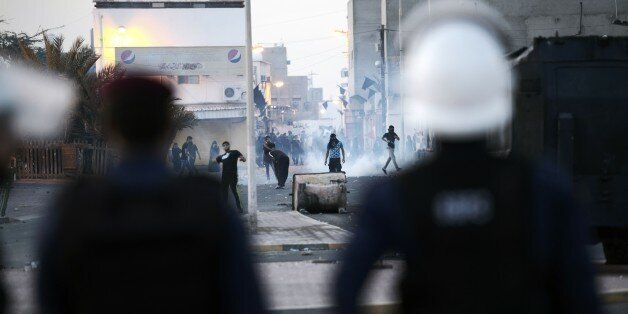 Bahraini protestors throw stones towards riot police during clashes following the funeral of Ali Abdulghani, 17, whose family says died of injuries suffered in a police chase, in the Shiite village of Shahrakkan, south of Manama on April 5, 2016. / AFP / MOHAMMED AL-SHAIKH (Photo credit should read MOHAMMED AL-SHAIKH/AFP/Getty Images)