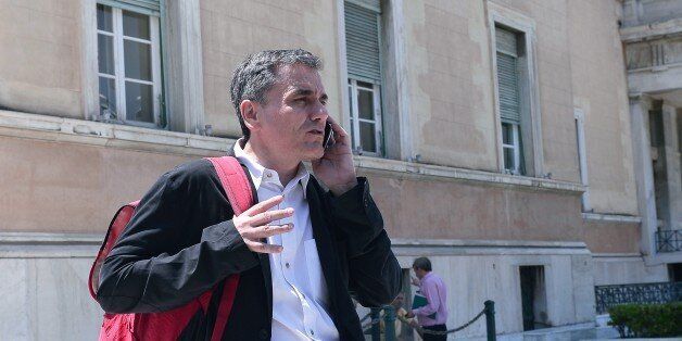 Greek Finance Minister Euclid Tsakalotos talks on his mobile phone outside the Greek parliament in Athens on July 22, 2015. Prime Minister Alexis Tsipras faced a new test of his authority in parliament on July 22, where MPs were to vote on a second batch of reforms to help unlock a bailout for Greece's stricken economy. The embattled premier last week faced a revolt by a fifth of the lawmakers in his radical-left Syriza party over changes to taxes, pensions and labour rules demanded by EU-IMF creditors. AFP PHOTO / LOUISA GOULIAMAKI (Photo credit should read LOUISA GOULIAMAKI/AFP/Getty Images)
