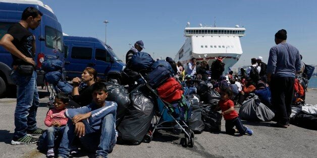 Refugees and migrants wait for a bus transporting them to a new refugee camp from the Athens port of Piraeus, on Monday, April 18, 2016. Hundreds of refugees and migrants continue to move at government-built shelters but more than 3,500 people remain at Piraeus. The Greek authorities are trying to evacuate the biggest port of the country, before Orthodox Easter on May 1, from refugees and migrants who are using tents and the terminal passenger buildings to stay. (AP Photo/Thanassis Stavrakis)