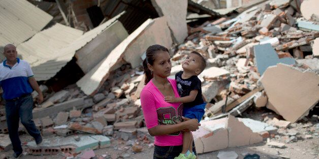 Elian Cevena walks with her son amid destroyed buildings while looking for shelter, after her house was destroyed in the 7.8-magnitude earthquake, in Portoviejo, Ecuador, Monday, April 18, 2016. The Saturday night quake left a trail of ruin along Ecuadorâs normally placid Pacific Ocean coast. Hundreds died and thousands are homeless. (AP Photo/Rodrigo Abd)