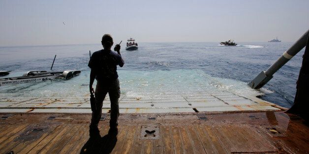 A U.S. Navy sailor assists during training exercises with small boats coming and going from the USS Ponce in the Persian Gulf, Sunday, April 10, 2016. The Bahrain-based U.S. Naval Forces Central Command is leading naval and civilian maritime forces from more than 30 countries in three weeks of mine countermeasure exercises aimed at keeping key shipping lanes secure from piracy, terrorism and mines. (AP Photo/Hasan Jamali)