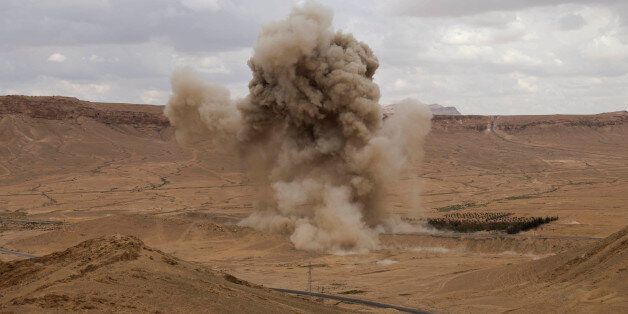 Smoke rises from a controlled land mine detonation by Russian experts in the ancient town of Palmyra in the central Homs province, Syria, Thursday, April 14, 2016. Russian combat engineers arrived in Syria on a mission to clear mines in Palmyra, which has been recaptured from Islamic State militants in an offensive that has proven Russia's military might in Syria despite a drawdown of its warplanes. (AP Photo/Hassan Ammar)