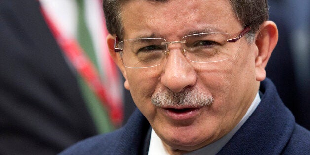 Turkish Prime Minister Ahmet Davutoglu, center, speaks with the media as he arrives for an EU summit in Brussels on Friday, March 18, 2016. Turkish Prime Minister Ahmet Davutoglu arrived for talks with EU Council President Donald Tusk, Commission President Jean-Claude Juncker and Dutch Prime Minister Mark Rutte. Their meeting is aimed at thrashing out the details of an agreement to send tens of thousands of migrants in Greece back to Turkey. (AP Photo/Geoffroy Van der Hasselt)