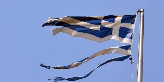 A ripped off Greek national flag flutters in central Athens on July 22, 2015. Prime Minister Alexis Tsipras faces a new test of his authority in parliament, where MPs are to vote on a second batch of reforms to help unlock a bailout for Greece's stricken economy.The embattled premier last week faced a revolt by a fifth of the lawmakers in his radical-left Syriza party over changes to taxes, pensions and labour rules demanded by EU-IMF creditors. .AFP PHOTO/ LOUISA GOULIAMAKI (Photo credit should read LOUISA GOULIAMAKI/AFP/Getty Images)