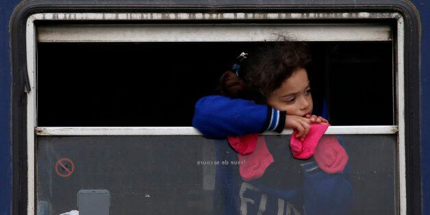 A migrant girl looks from inside a rail car at a train station near a make shift refugee camp at the northern Greek border point of Idomeni, Greece, Tuesday, March 29, 2016. More than 15,000 people - nearly a third of the total stranded in Greece - are refusing to move to government-built shelters around the country, and remain at the border with Macedonia and at the port of Piraeus, near Athens. (AP Photo/Darko Vojinovic)