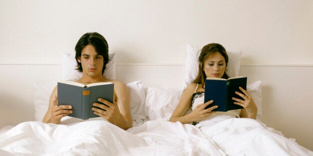 couple lying in bed, reading books