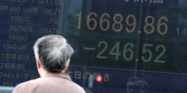 A man looks at an electronic stock board at a securities firm in Tokyo Friday, March 18, 2016. Asian stocks mostly advanced on Friday as higher prices for commodities, including crude oil, pushed Wall Street stocks higher overnight. But shares in Tokyo fell as the yen's strength worried investors. (AP Photo/Eugene Hoshiko)