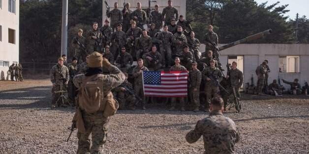 In a photo taken on March 15, 2016 US soldiers of the 13th Marine Expeditionary Unit pose for a photo as they take part in an exercise entitled 'Ssang Yong', near South Korea's southeastern port city of Pohang.Ssang Yong, meaning 'twin dragons', is a biennial military exercise 'focused on strengthening the amphibious landing capabilities of the U.S. and its allies', according to the US Pacific Command. The 11-day exercise brings together US Marines of the 13th and 31st Marine Expeditionary Units and their South Korean counterparts. On March 12, North Korea hit out at Washington and Seoul, pledging to launch a blitzkrieg in the Korean peninsula, with the official KCNA news agency, citing a statement from military chiefs, warning of a 'pre-emptive retaliatory strike at the enemy groups' involved in the joint US-South Korean exercise. / AFP / Ed Jones (Photo credit should read ED JONES/AFP/Getty Images)