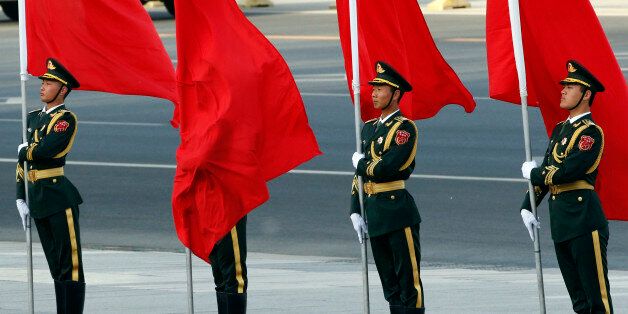 A red flag covers a soldier from Chinese honour guards during a welcoming ceremony for Swiss President Johann Schneider-Ammann at the Great Hall of the People in Beijing, China, April 8, 2016. REUTERS/Kim Kyung-Hoon