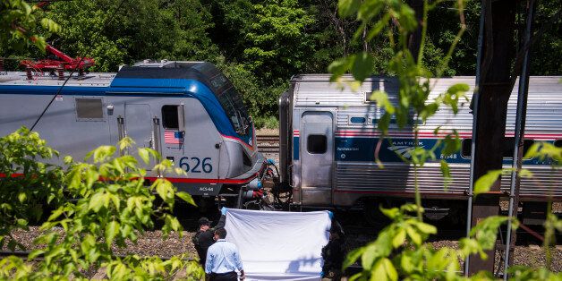 WASHINGTON, DC - MAY 14: An Amtrak train slowly crawls by officers as they hold up a sheet covering remains after a person was fatally struck by a train near 16th St. and New York Ave halting train service between D.C. and Baltimore in Washington, DC on Thursday May 14, 2015. (Photo by Jabin Botsford/The Washington Post via Getty Images)